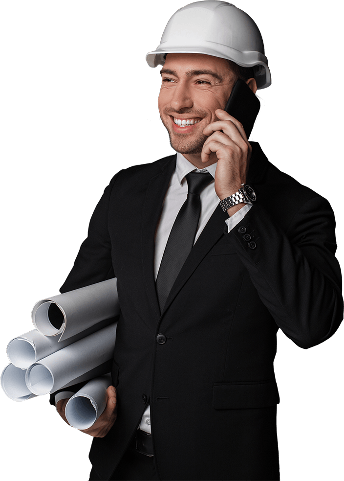 Homem branco sorrindo com capacete de segurança, vestindo terno e atendendo ligação no celular, segurando projetos na mão
